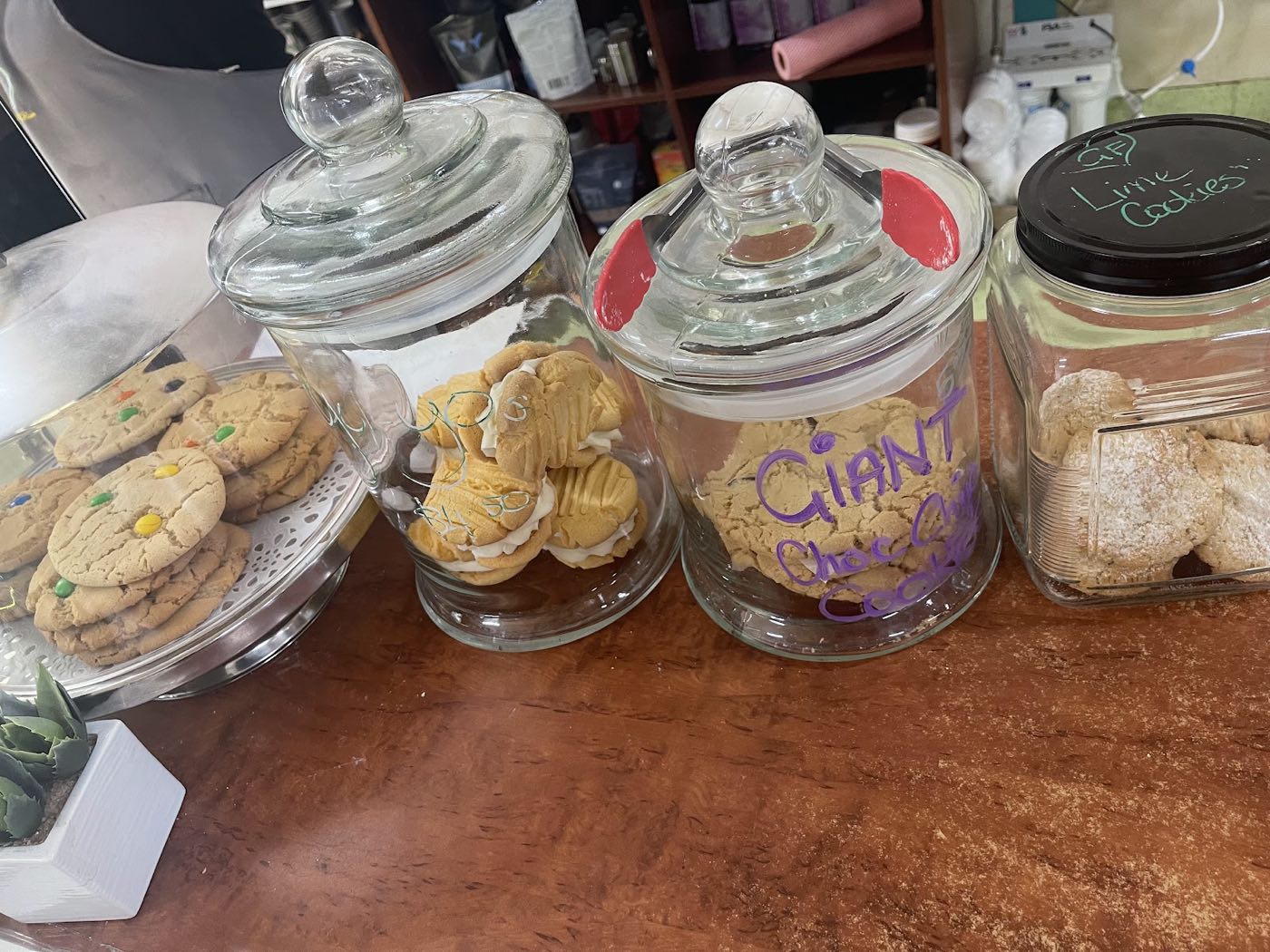 Glass jars and a cake stand of biscuits on the counter, one jar labelled Giant